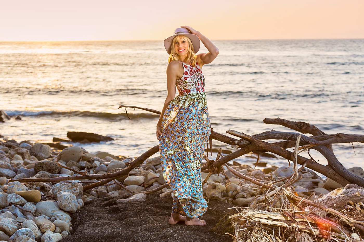 Anthropologie dress and Michael Stars hat in a turning pose on the beach